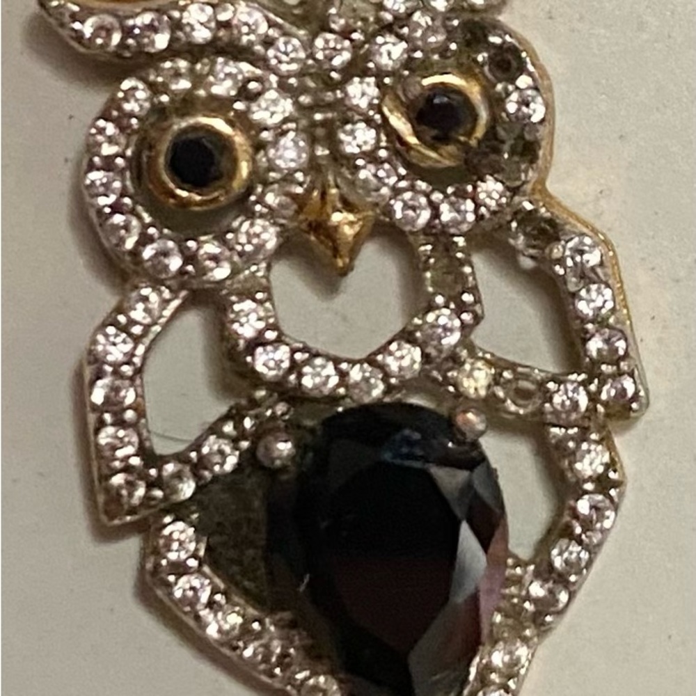 Gold or gold plated with either diamonds or cz. Owl pendant black & white stones